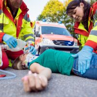 Emergency doctor ventilating injured woman after motorbike accident