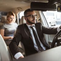 driver and businesswoman in car